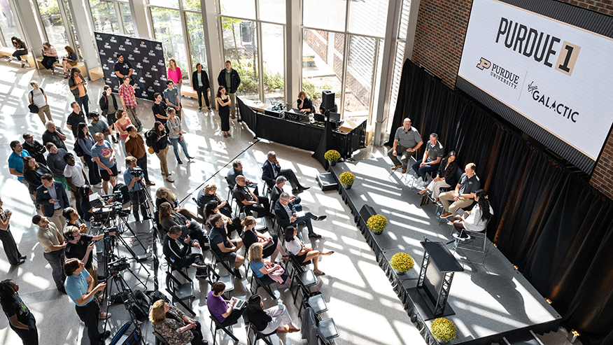 Purdue and Virgin Galactic panel discussion in a bright atrium.